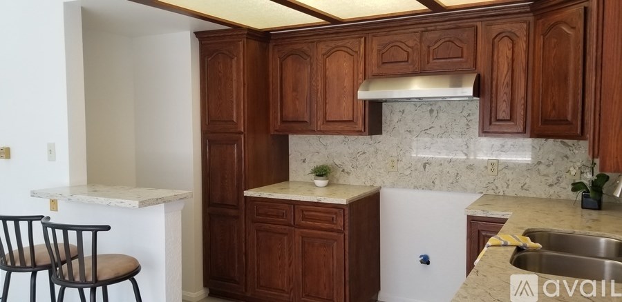 A kitchen with brown cabinets and a white countertop.
