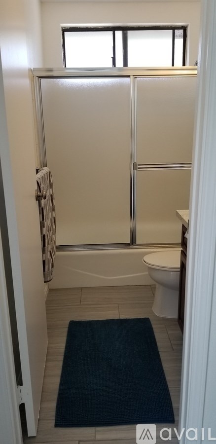 A bathroom with a toilet, sink, and a window.