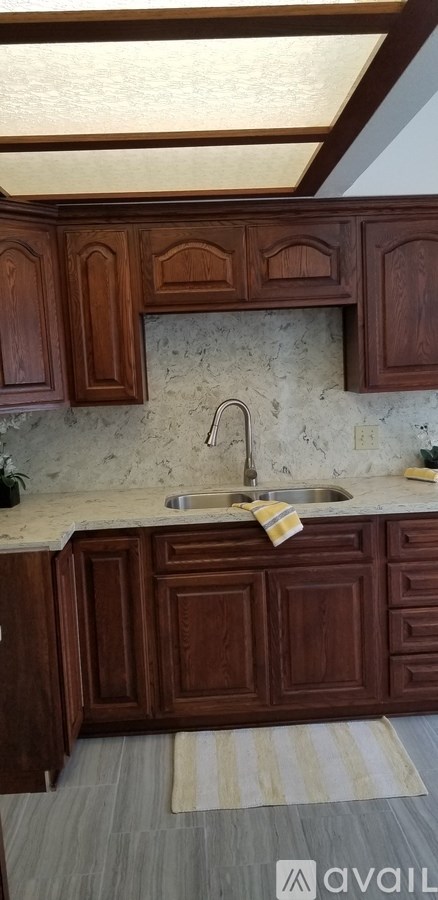 A kitchen with wooden cabinets and a marble backsplash.