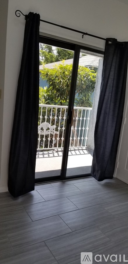 A balcony with a black curtain and a white railing.