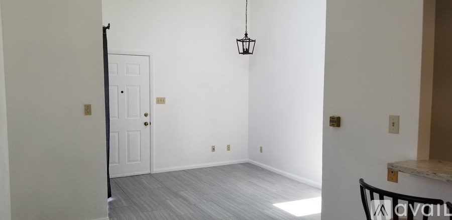 A room with a white door and a hanging light fixture.