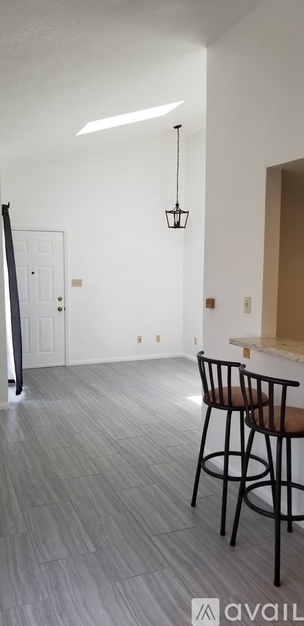 A room with a bar stool and a white door.