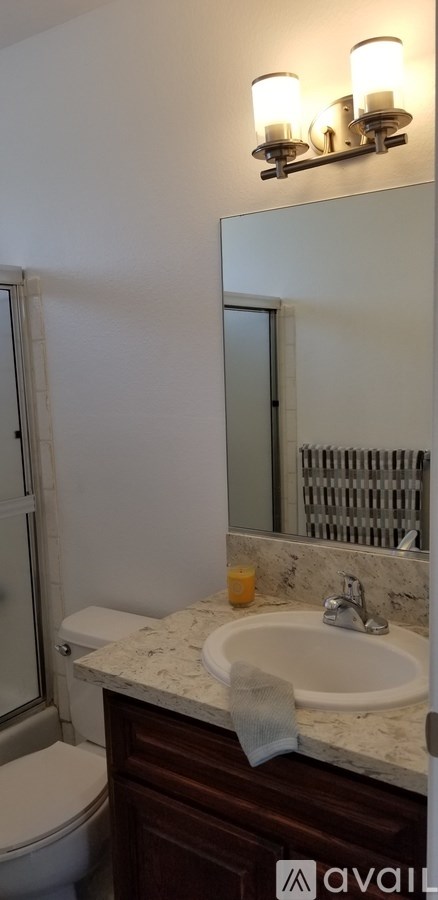 A bathroom with a sink, mirror, and toilet.