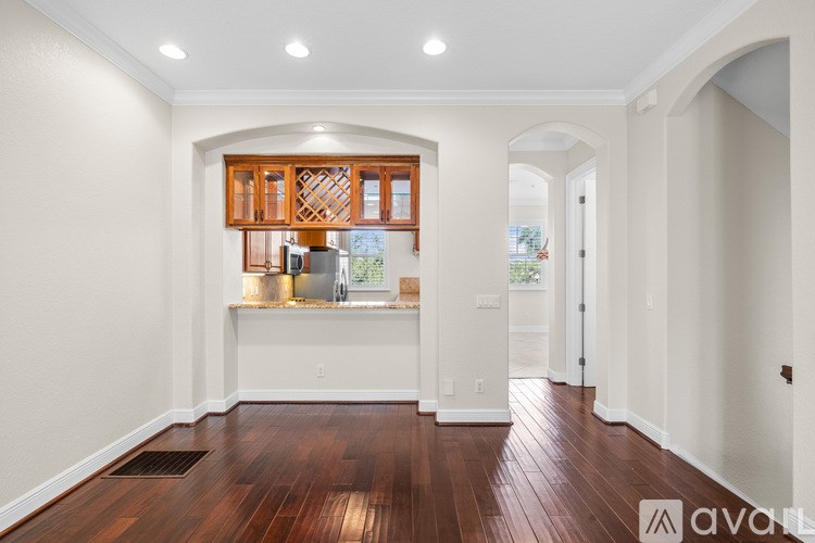 A spacious room with wooden floors and white walls.