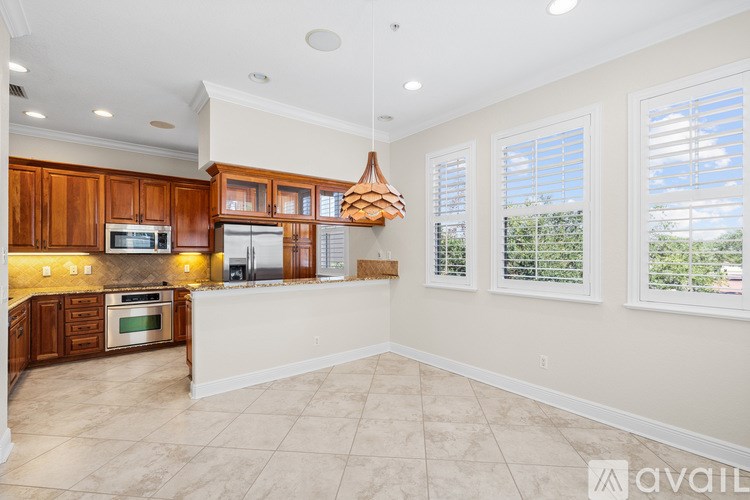 A kitchen with wooden cabinets and a tiled floor.