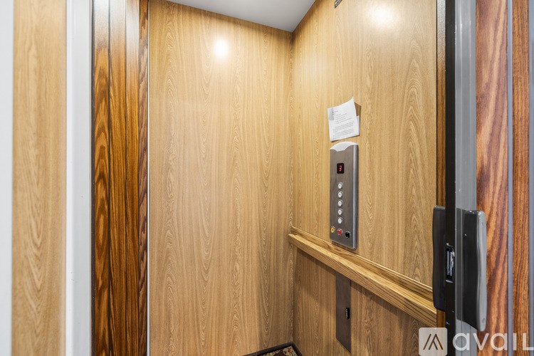 A wooden door with a control panel and a black handle.