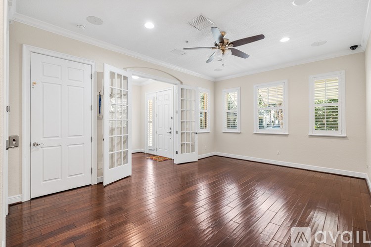 A room with a ceiling fan and wooden floors.