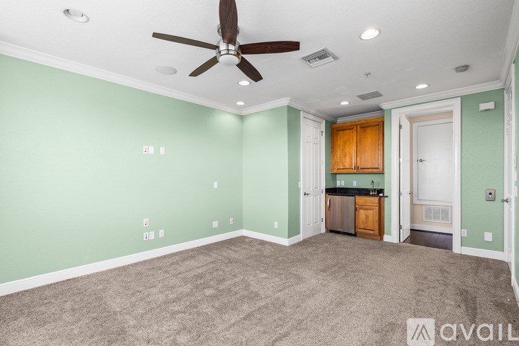 A room with a ceiling fan and carpeted floor.