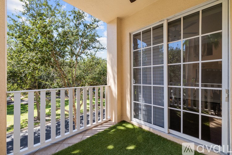 A balcony with a white railing and a glass door.
