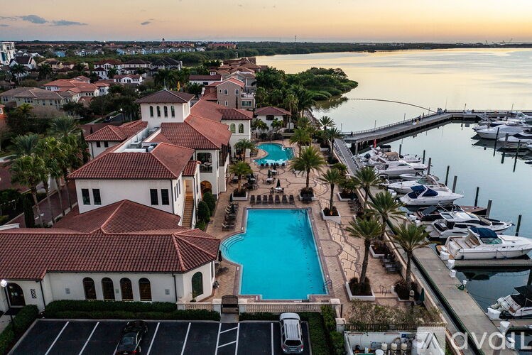 A marina with boats docked and a building with a pool in the foreground.