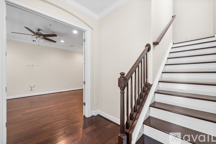 A staircase with a wooden handrail and white steps.