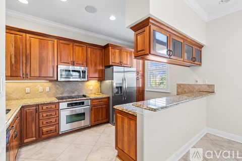 A kitchen with wooden cabinets and a granite countertop.