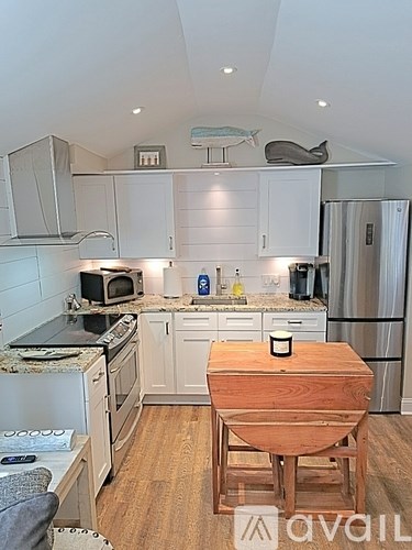 A kitchen with a wooden table and a refrigerator.