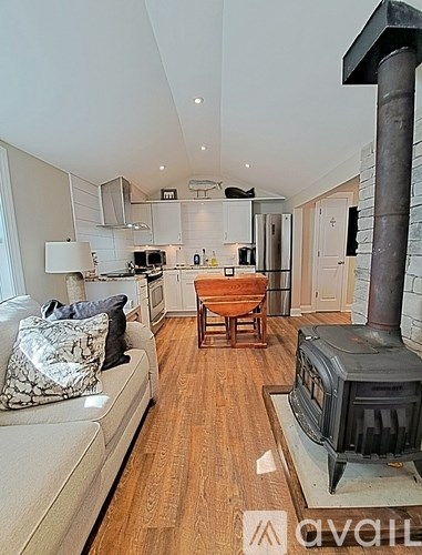 A modern living room with a wood stove and a dining area.