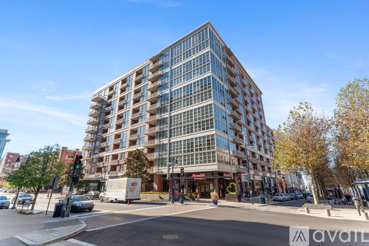 A tall building with many windows is located on a street corner.