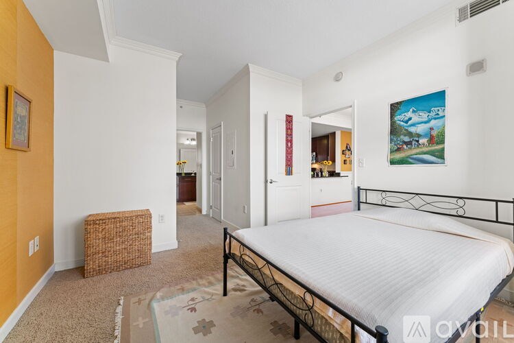A bedroom with a large bed and a painting on the wall.