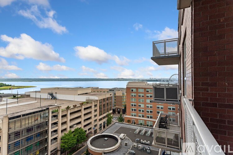 A balcony overlooks a parking lot and buildings.