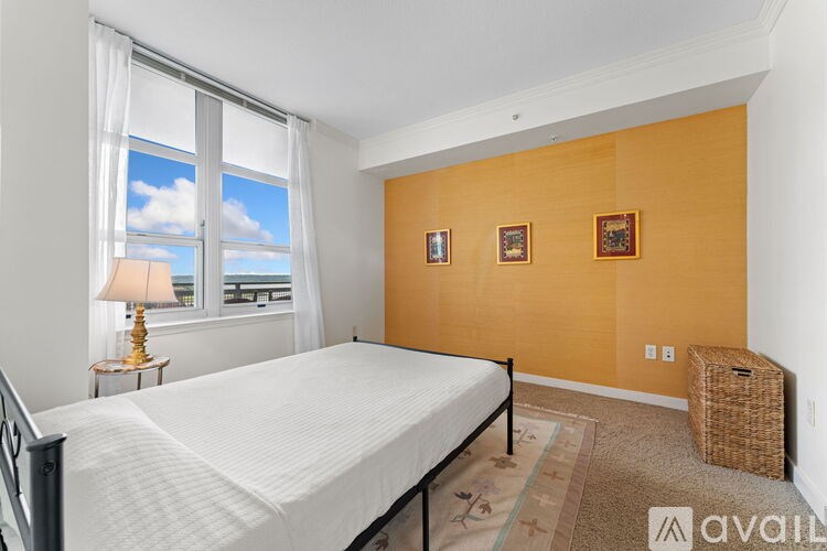 A bedroom with a large bed and a window with a view of the sky.