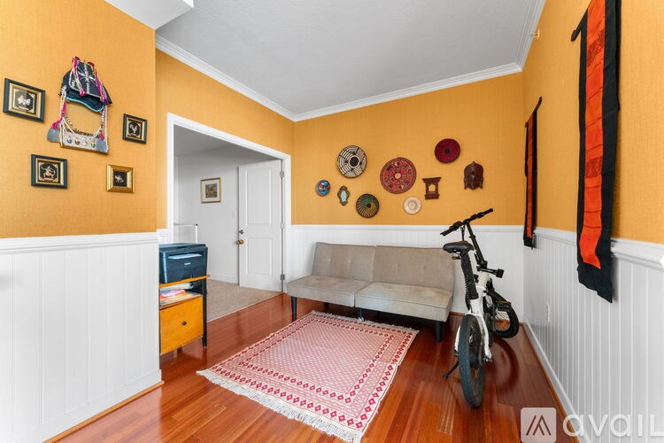 A room with a bicycle and a sofa.