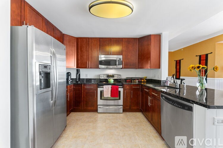 A kitchen with wooden cabinets and a stainless steel refrigerator.