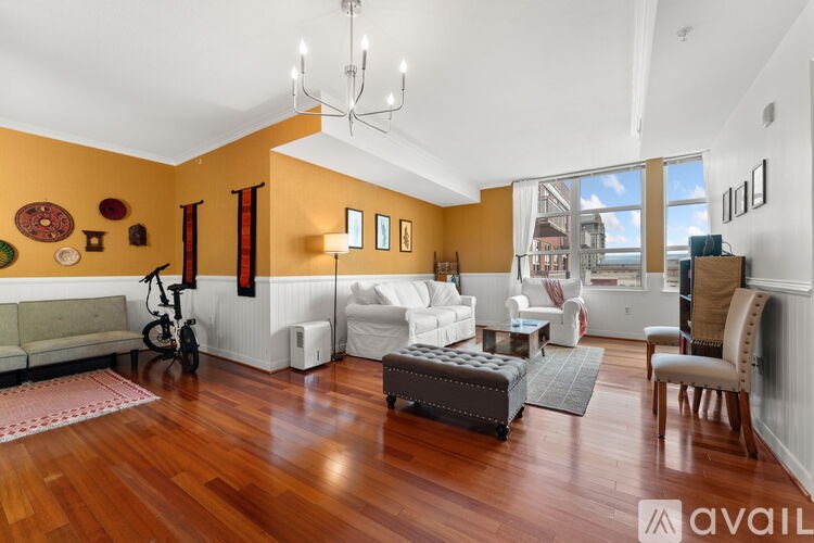 A living room with a white couch and a wooden floor.