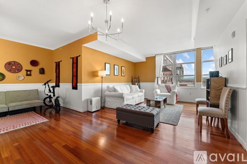 A living room with a white couch and a wooden floor.