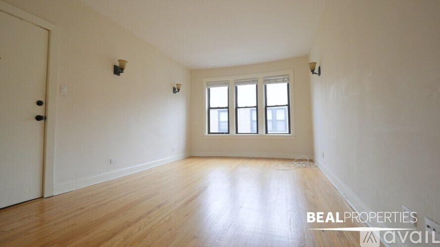 A room with wooden floors and a large window.
