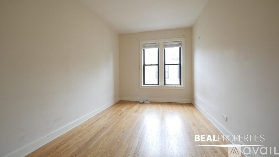 A room with wooden flooring and a window.
