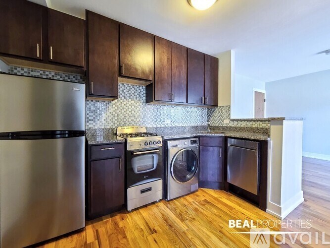 A kitchen with wooden cabinets and a stainless steel refrigerator.