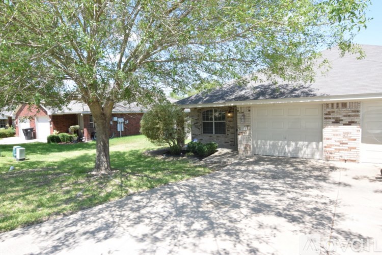A tree is in front of a house.
