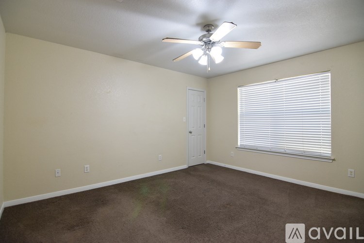 A room with a carpeted floor and a window.
