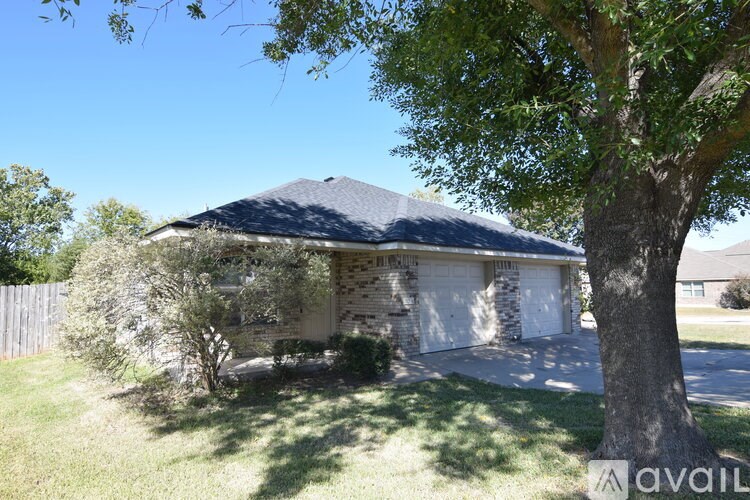 A bathroom with a toilet, sink and wooden cabinet.