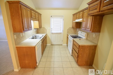 A kitchen with wooden cabinets and a white stove top oven.