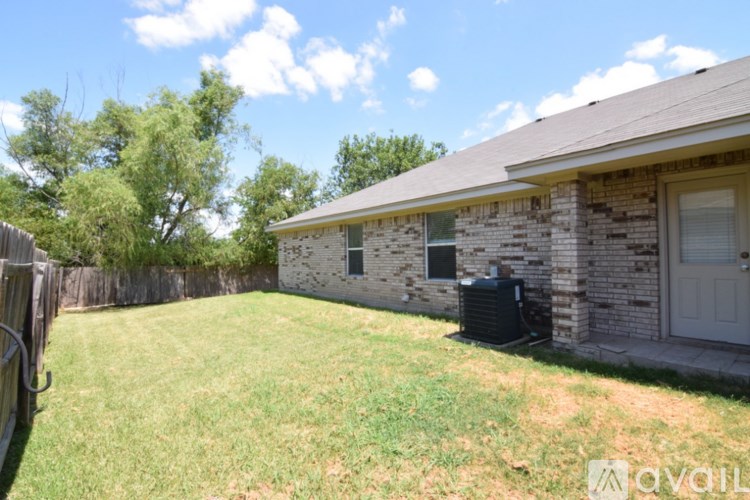 A house with a lawn and a fence in front of it.
