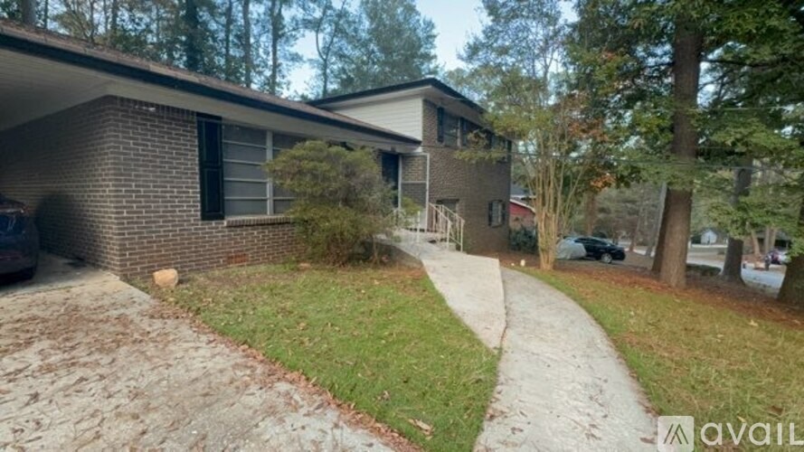 A house with a driveway and a tree in front.