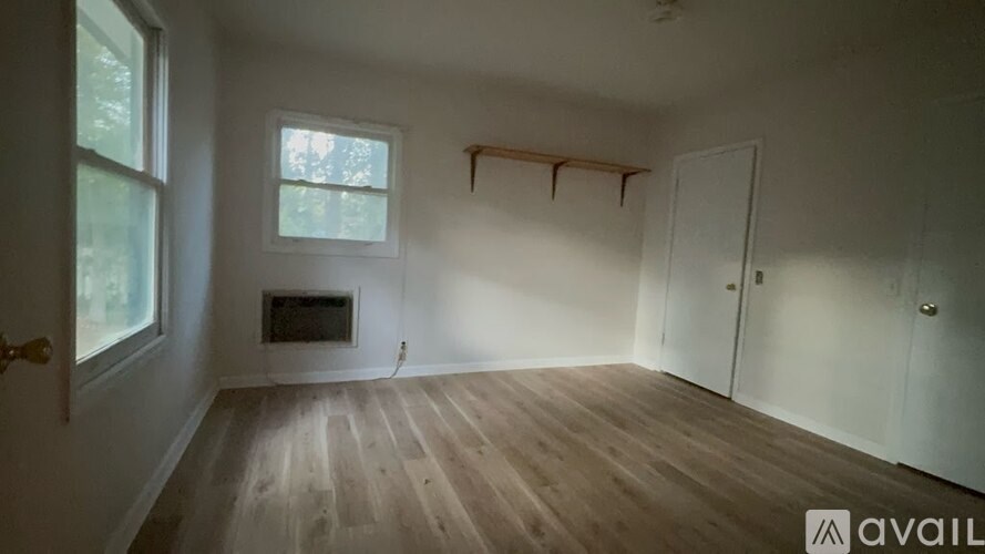 A room with wooden floors and a fireplace is available for rent.