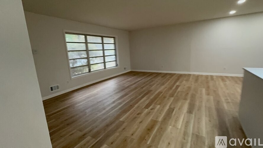 A room with wooden flooring and a window.