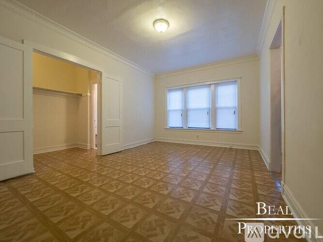 A room with a wooden floor and a window.