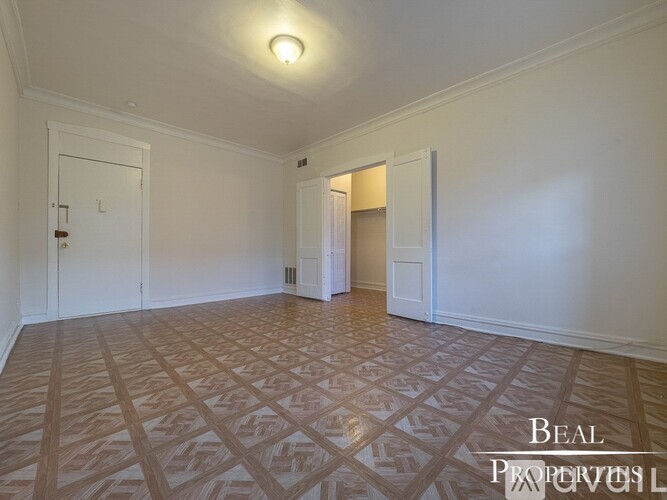 A room with a patterned floor and a door on the left.