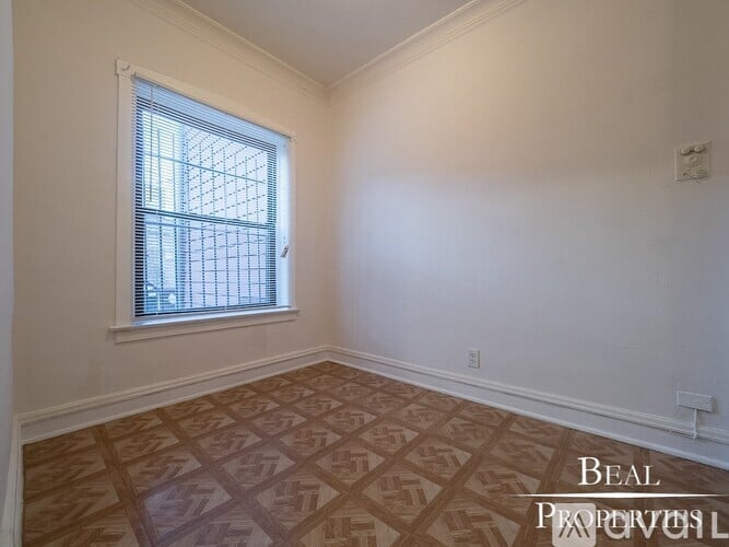 A room with a window and a wooden floor.