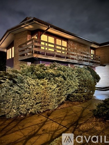 A house with a well-manicured hedge in front.