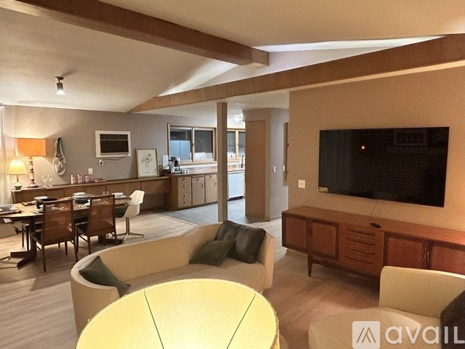 A living room with a yellow table and a television on the wall.