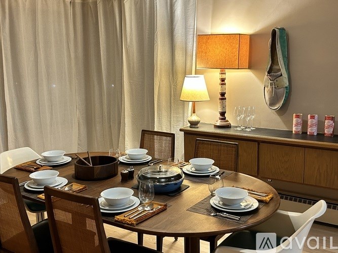 A dining table set with plates and glasses is ready for a meal.