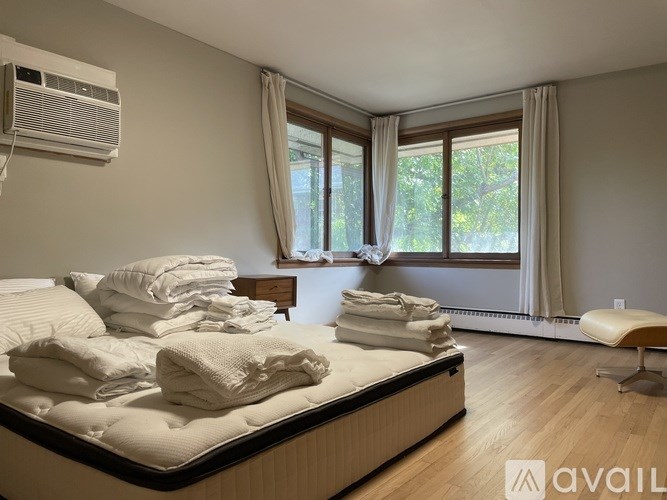 A bedroom with a large bed and a window with curtains.