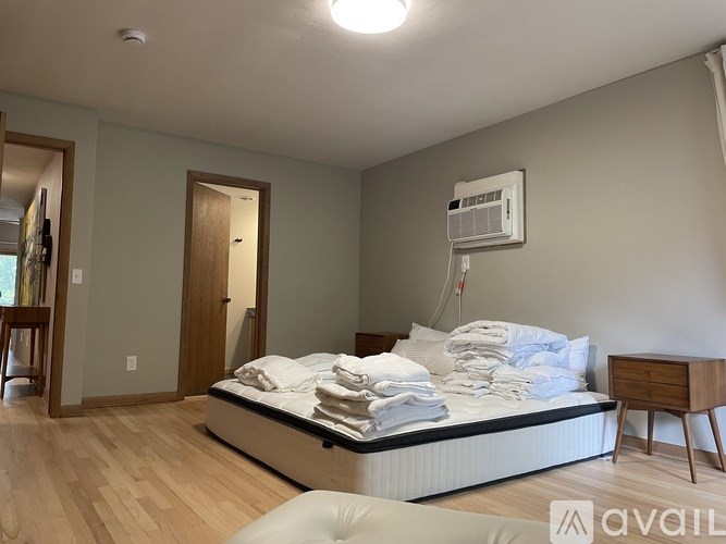 A bedroom with a bed, nightstand, and chair.