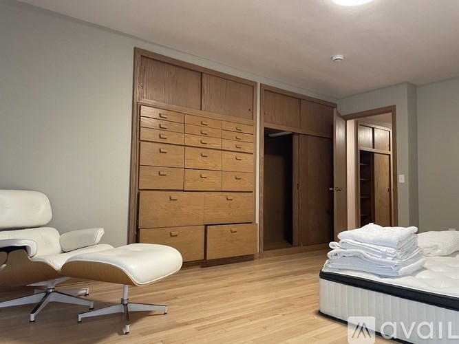 A bedroom with a bed, chair, and wardrobe.