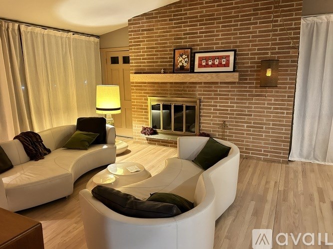 A modern living room with a white sofa and a black chair.