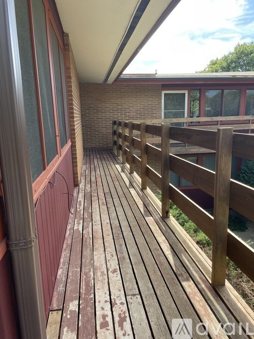 A deck with a railing and a red wall.