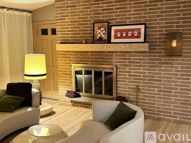 A living room with a white couch and a brick wall.