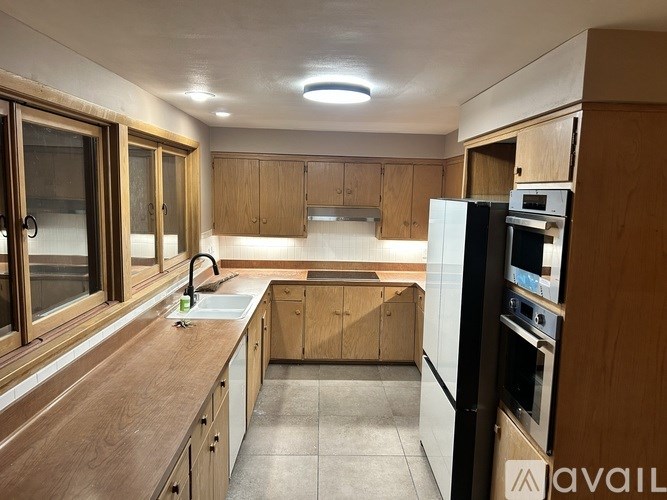 A kitchen with wooden cabinets and a white refrigerator.